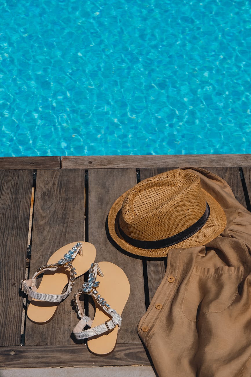 shoes and a hat by a swimming pool